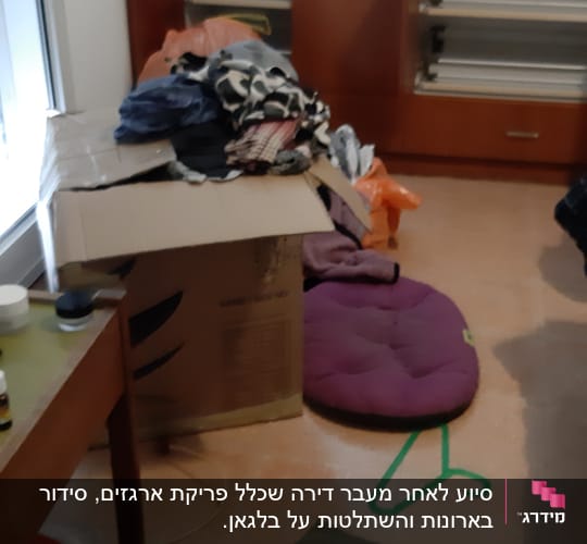 בגדים מקופלים על קופסה, קולבים ירוקים על הרצפה